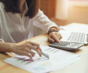 Businesswoman in office and use computer and calculator to perform financial accounting